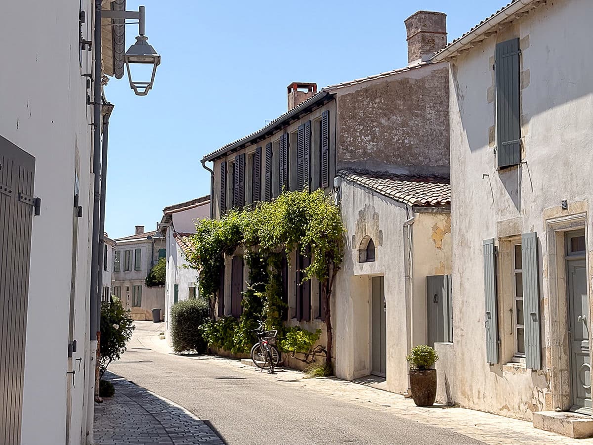 Rue pittoresque avec maisons en pierre et vélo.