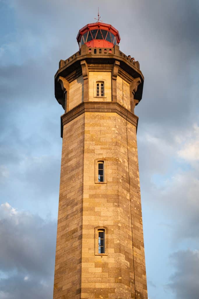 Phare en pierre sous un ciel nuageux.