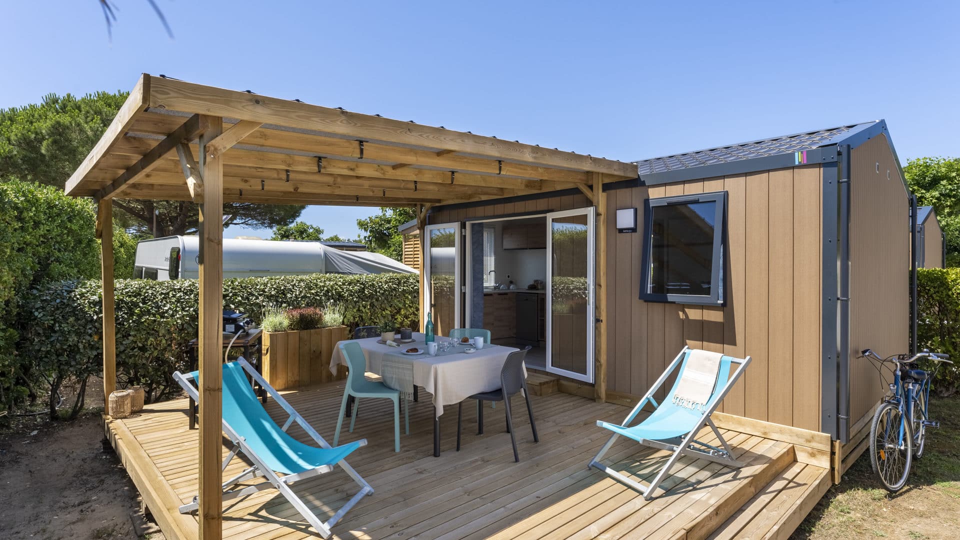 Terrasse en bois avec chaises longues et table.
