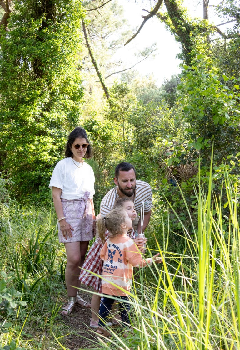 Famille explorant la nature dans la forêt verdoyante.