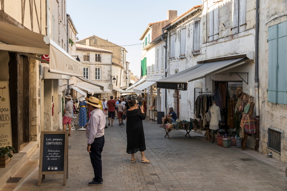 Rue commerçante animée avec piétons en France.